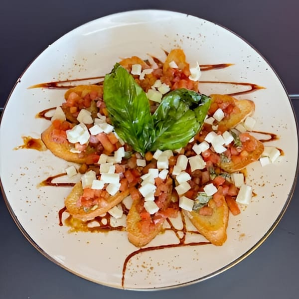 Scarpino's bruschetta with diced tomatoes, mozzarella, and basil, drizzled with balsamic glaze.