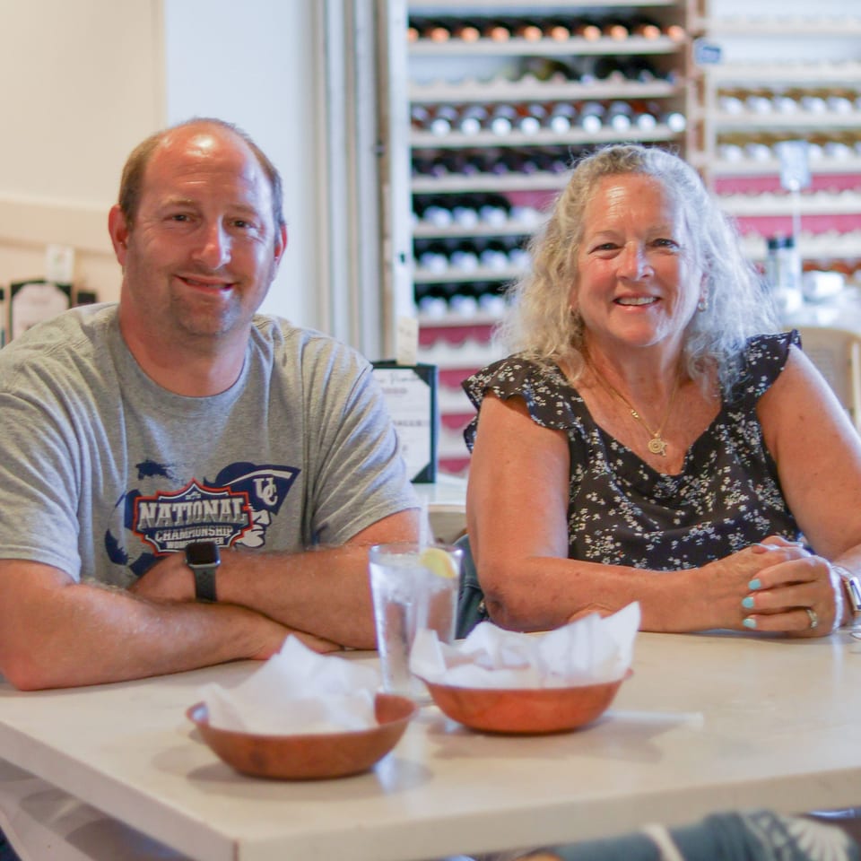 A smiling man and woman seated at a table in Scarpino's Classic Italian restaurant.