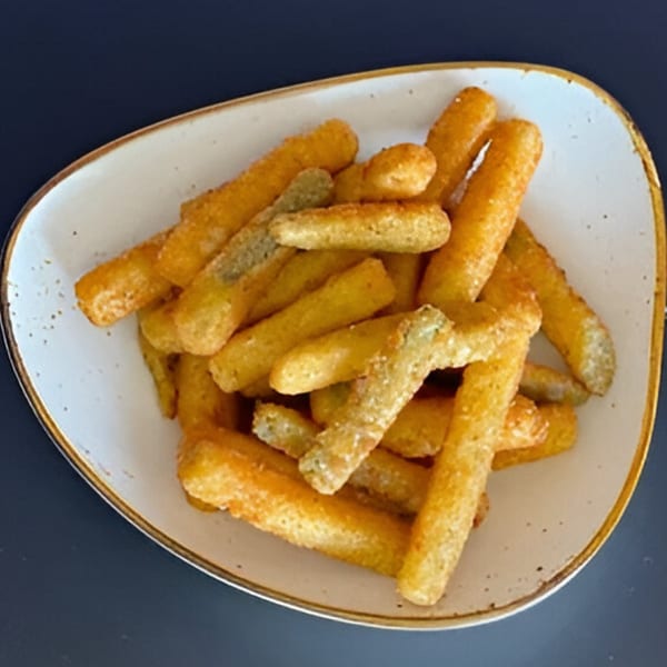 A white bowl filled with golden-brown, crispy Italian breadsticks, some lightly dusted with seasoning.
