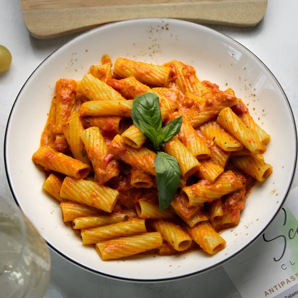 Rigatoni pasta with red sauce and fresh basil in a white bowl at Scarpino's Classic Italian.
